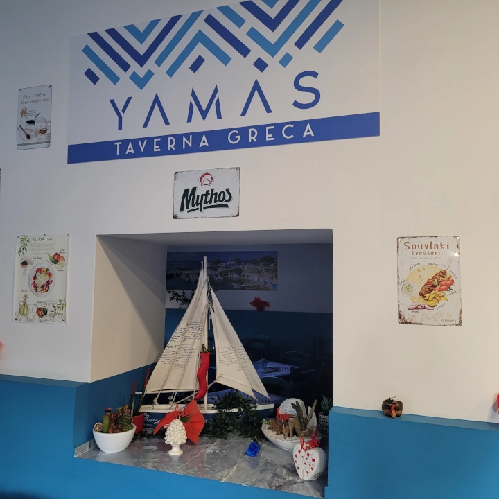 Interno accogliente della taverna YAMAS con decorazioni tradizionali greche