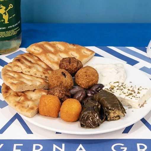 Piatto di antipasto Yamas greco con feta, olive nere, polpette miste e involtini di foglie di vite (dolmades)